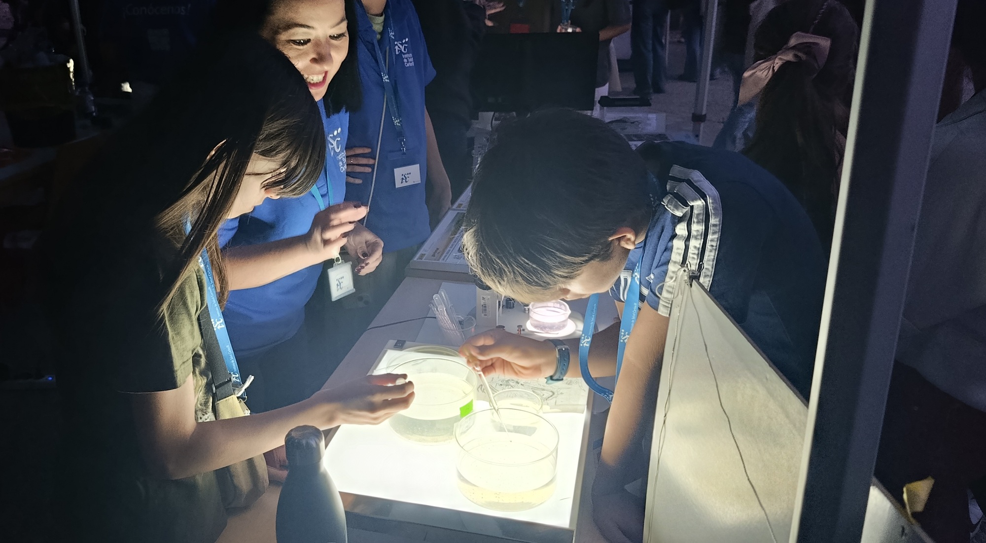 Un grupo de chicos y chicas llevan a cabo un pequeño experimento con investigadoras del Instituto, en una de las actividades llevadas a cabo en la Noche de los Investigadores/as 2025.